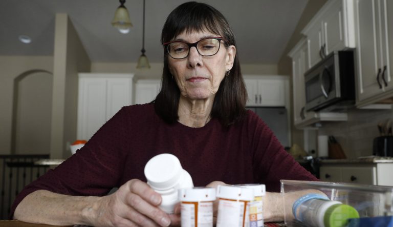 Retired public school teacher Gail Orcutt, of Altoona, Iowa, looks over some of the prescription drugs she takes, Friday, Feb. 15, 2019, in Altoona, Iowa. 