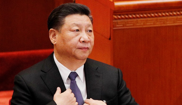 Chinese President Xi Jinping adjusts his jacket as he arrives for a plenary session of China's National People's Congress in Beijing.