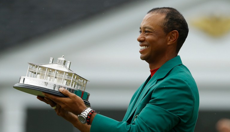 Tiger Woods wears his green jacket holding the winning trophy after the final round for the Masters golf tournament in Augusta, Ga. 