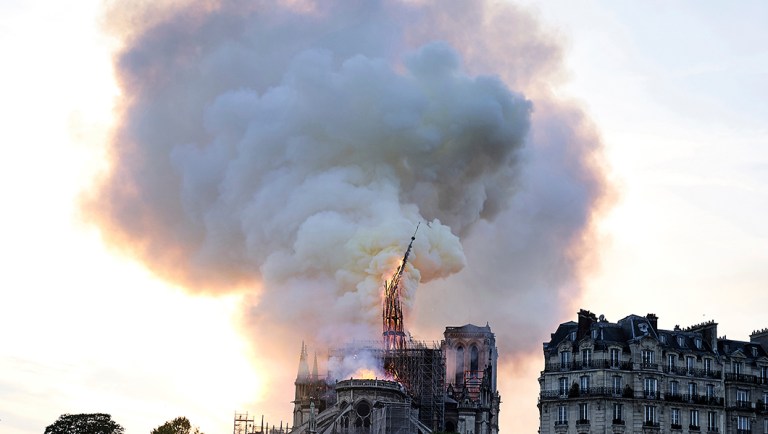 Flames and smoke rise as the spire on Notre Dame cathedral collapses in Paris.
