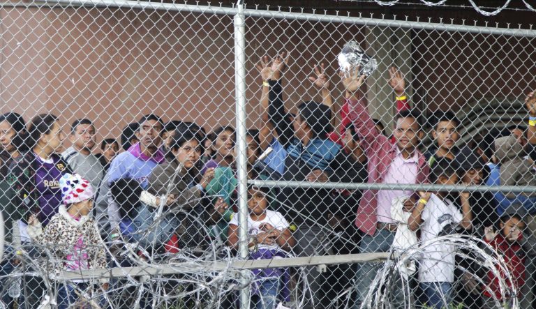 In this March 27, 2019 photo, Central American migrants wait for food in a pen erected by U.S. Customs and Border Protection to process a surge of migrant families and unaccompanied minors in El Paso, Texas. 