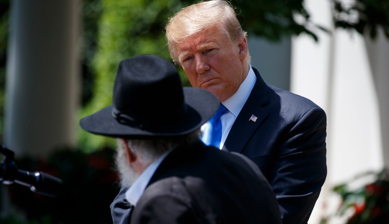 President Donald Trump looks on as Rabbi Yisroel Goldstein, survivor of the Poway, Calif synagogue shooting, speaks during a National Day of Prayer event in the Rose Garden of the White House, Thursday, May 2, 2019, in Washington.