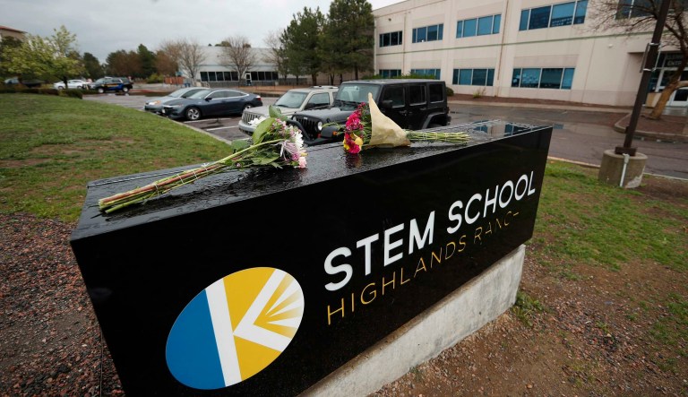 Bouquet of flowers sit on the sign outside the STEM School Highlands Ranch late Wednesday, May 8, 2019, in Highlands Ranch, Colo.