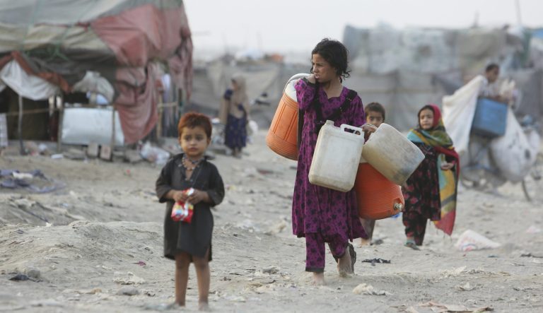 Afghan refugees who fled their homeland due to war and famine, are on their way to collect clean water in slums of Lahore, Pakistan, Wednesday, June 19, 2019. 