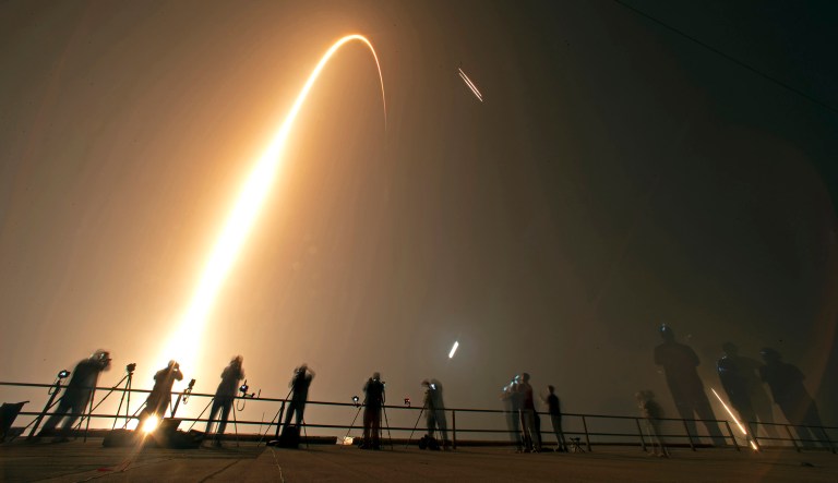 Photographers on the roof of the Vehicle Assembly building capture the launch and rocket boosters landing of a SpaceX Falcon heavy rocket at the Kennedy Space Center in Cape Canaveral, Florida.