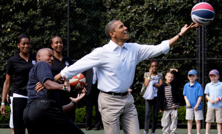 In this April 9, 2012 photo, President Barack Obama plays basketball with former NBA basketball player Bruce Bowen during the annual White House Easter Egg Roll at the White House in Washington.