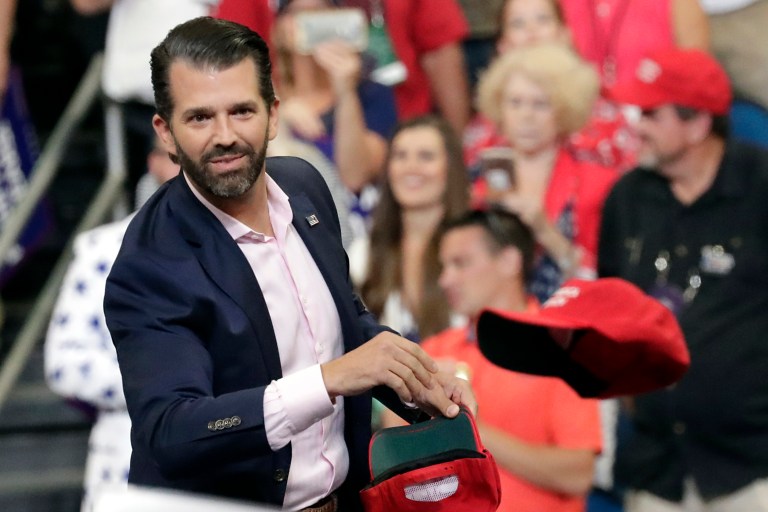 Donald Trump Jr. throws hats to supporters at a campaign rally for President Donald Trump in Orlando, Fla. in June.