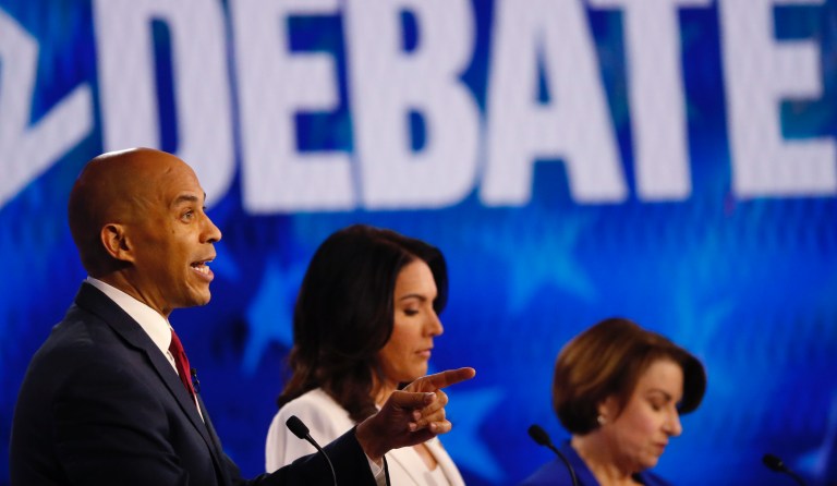 Democratic presidential candidate Sen. Cory Booker, D-N.J., left, speaks as Democratic presidential candidate Rep. Tulsi Gabbard, D-Hawaii, and Democratic presidential candidate Sen. Amy Klobuchar, D-Minn., from left, look on during a Democratic presidential primary debate, Wednesday, Nov. 20, 2019, in Atlanta.