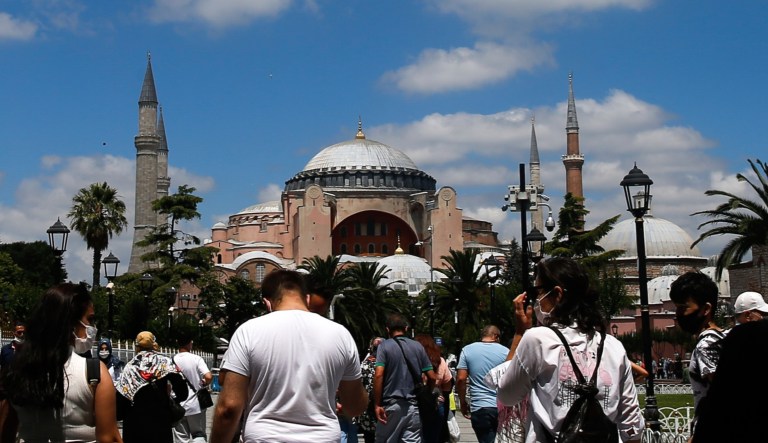 People walk towards the now-closed Byzantine-era Hagia Sophia, one of Istanbul's main tourist attractions in the historic Sultanahmet district of Istanbul on Saturday. Turkey's President Recep Tayyip Erdogan formally reconverted Hagia Sophia into a mosque and declared it open for Muslim worship, hours after a high court annulled a 1934 decision that had made the religious landmark a museum.
