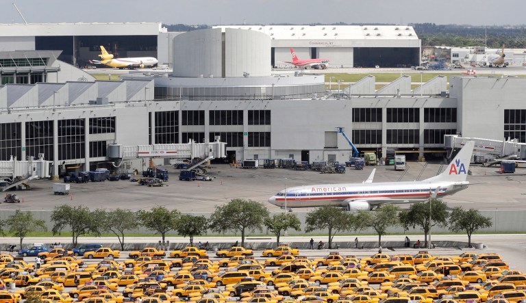 A people mover goes to the terminal as taxis wait in a holding area at Miami International Airport in Miami.  