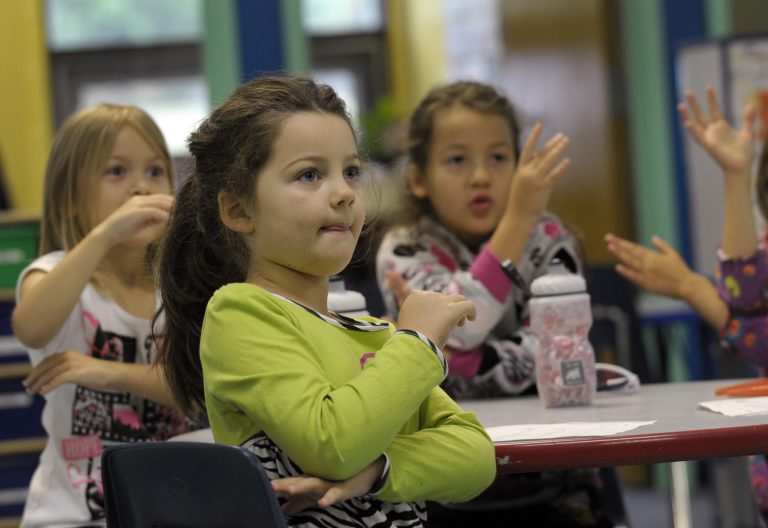 In this picture, several children are trying to learn sign language.