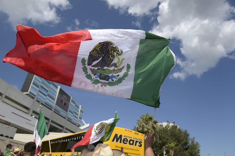 People wave Mexican flags.