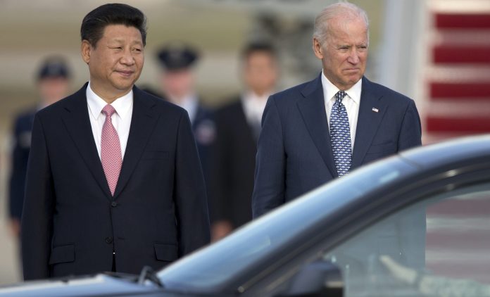 Chinese President Xi Jinping and former Vice President Joe Biden stand together as President Xi Jinping prepares to board a motorcade during an arrival ceremony at Andrews Air Force Base, Md., Thursday, Sept. 24, 2015. 
