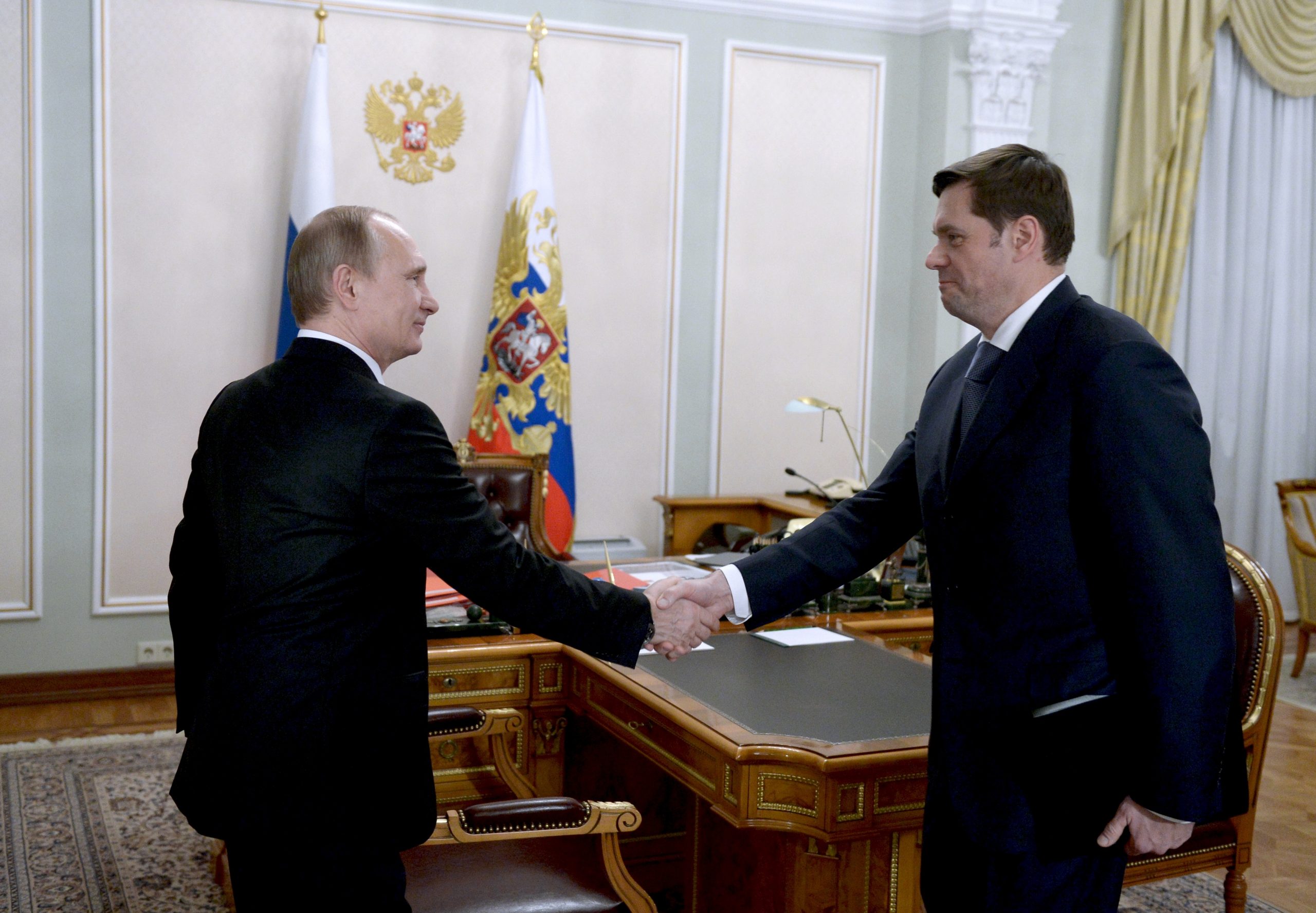 In this photo taken on Jan. 19, 2015, Russian President Vladimir Putin, left, shakes hands with Severstal's Chief Executive Alexei Mordashov during their meeting in the Novo-Ogaryovo residence outside Moscow. Severstal is a Russian steel producer based in northwest Russia. 