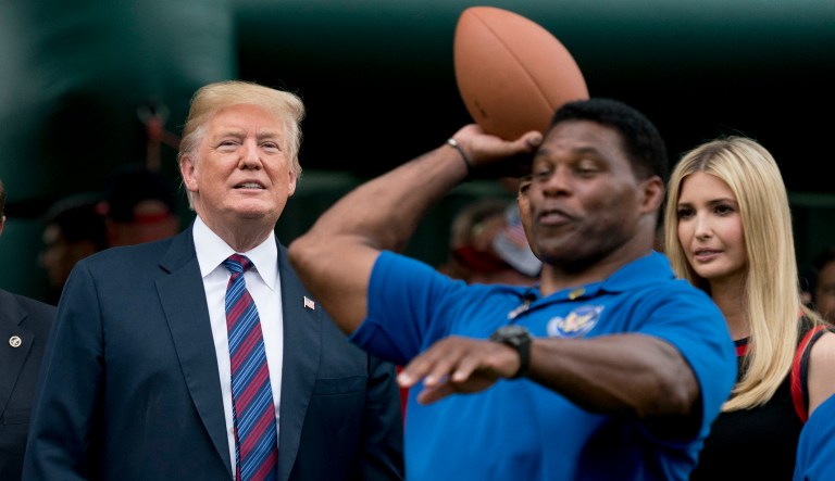 Former President Donald Trump, left, and his daughter Ivanka Trump, right, watch as football legend and Trump friend Herschel Walker, center, throws football's during White House Sports and Fitness Day on the South Lawn of the White House, Tuesday, May 29, 2018. Trump feels Walker would be a good Georgia gubernatorial candidate.