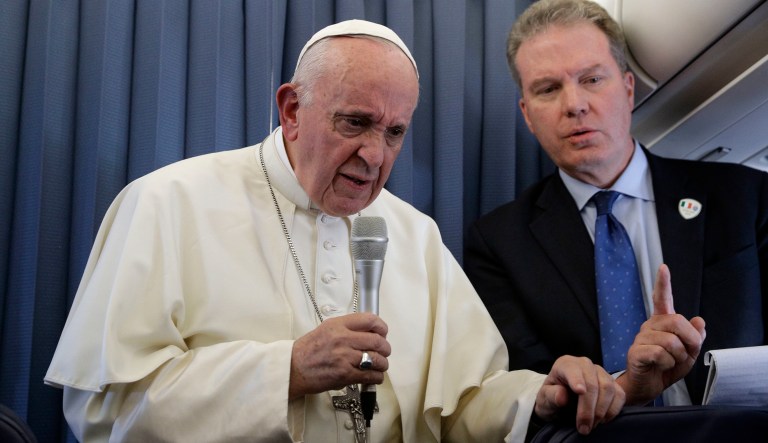 Pope Francis, flanked by Vatican spokesperson Greg Burke, listens to a journalist's question during a press conference aboard of the flight to Rome at the end of his two-day visit to Ireland. 