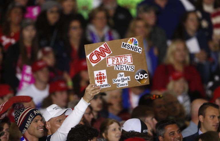 An audience member holds a 'fake news' sign during a 2018 Trump rally in Washington Township, Mich. Polls showing a huge lead for Joe Biden are under fire for manipulating the data.