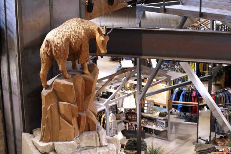 A carved mountain goat looks down at the lower level in REI Co-op's flagship store in Seattle.