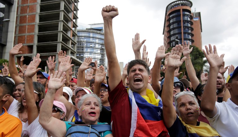 Anti-government protesters cheer after Juan Guaido, head of Venezuela's opposition-run congress, declares himself interim president of the South American country until new elections can be called, at a rally demanding the resignation of President Nicolas Maduro, in Caracas, Venezuela, Wednesday, Jan. 23, 2019. 