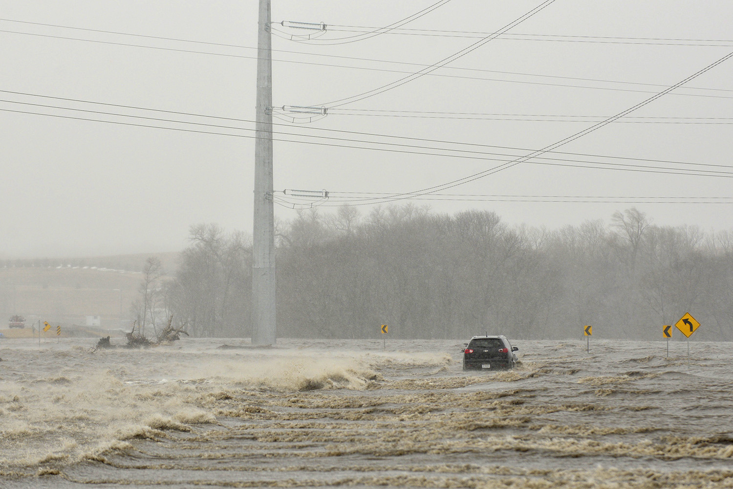 An abandoned car sits on Industrial Highway in flood waters north of Norfolk, Neb. According to a trooper on scene, the occupant had to be rescued. Thousands of people have been urged to evacuate along eastern Nebraska rivers as a massive late-winter storm has pushed streams and rivers out of their banks throughout the Midwest.