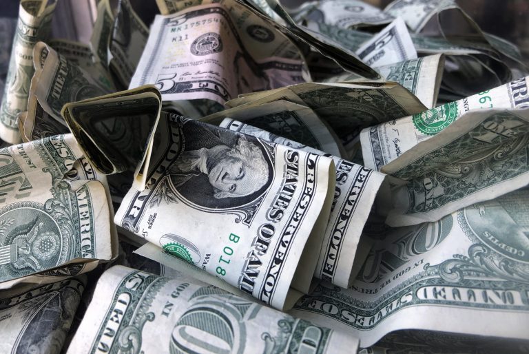 FILE - This April 3, 2019, file photo shows a tip box filled with U.S. currency in New York. (AP Photo/Mark Lennihan, File)
