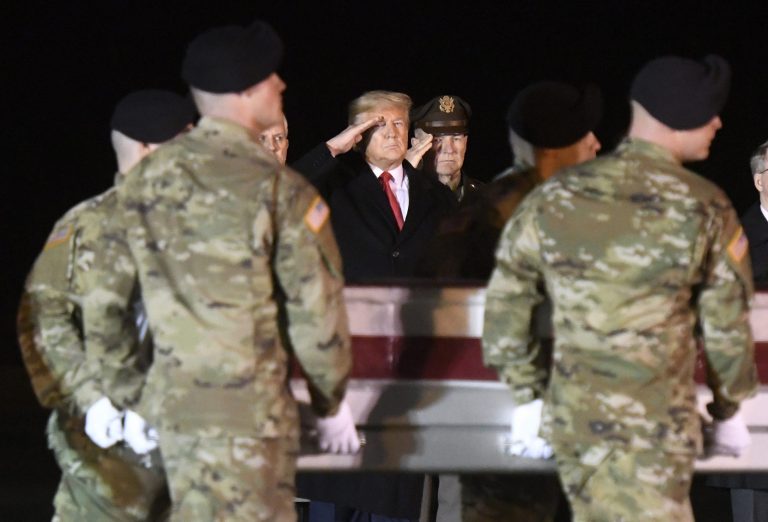 President Donald Trump, center, and Army Chief of Staff Gen. James C. McConville, right of center, salute as an Army carry team moves a transfer case containing the remains of Sgt. 1st Class Antonio Rey Rodriguez, Monday, Feb. 10, 2020, at Dover Air Force Base, Del. According to the Department of Defense, Rodriguez, 28, of Las Cruces, N.M., died in Nangarhar province, Afghanistan, of wounds sustained during combat operations.