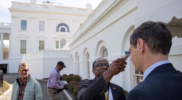 A member of the media, right, gets their temperature taken by member of the White House physicians office, over concerns about the coronavirus outside the James Brady Briefing Room at the White House, Saturday, March 14, 2020, in Washington.