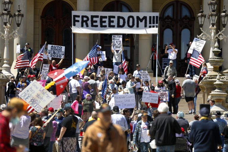 People protest at the State Capitol during a rally in Lansing, Mich., Wednesday, May 20, 2020. Barbers and hair stylists are protesting the state's stay-at-home orders, a defiant demonstration that reflects how salons have become a symbol for small businesses that are eager to reopen two months after the COVID-19 pandemic began.