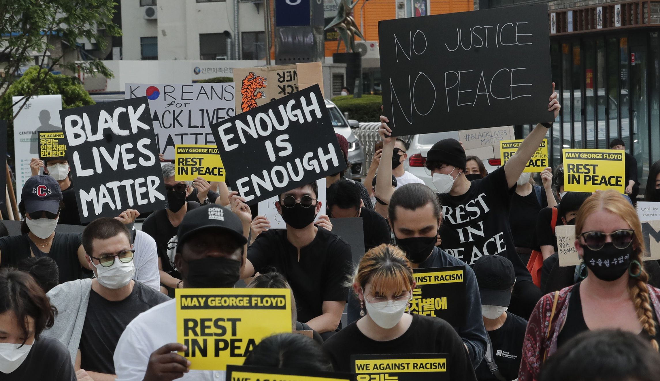 People kneel to protest on June 6 during a solidarity rally in Seoul against the death of George Floyd. Floyd died after being restrained by Minneapolis police officers on May 25.