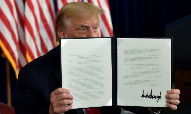President Donald Trump signs an executive order during a news conference at the Trump National Golf Club in Bedminster, N.J.