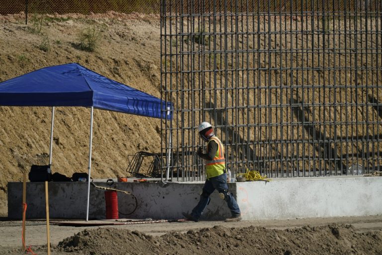 A construction worker walks along where a border wall is being built in Mission, Texas, Monday, Nov. 16, 2020.  Joe Biden would face immediate pressure to fulfill his pledge to stop border wall construction.