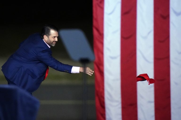 Donald Trump Jr. throws hats into the crowd before President Donald Trump arrives for a campaign rally in Dalton, Ga., Monday, Jan. 4, 2021. He is eyeing his own tour to take on President Biden.