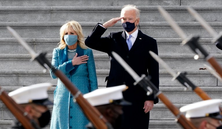 President Joe Biden and his wife Jill Biden watch a military pass in review ceremony on the East Front of the Capitol at the conclusion of the inauguration ceremonies.
