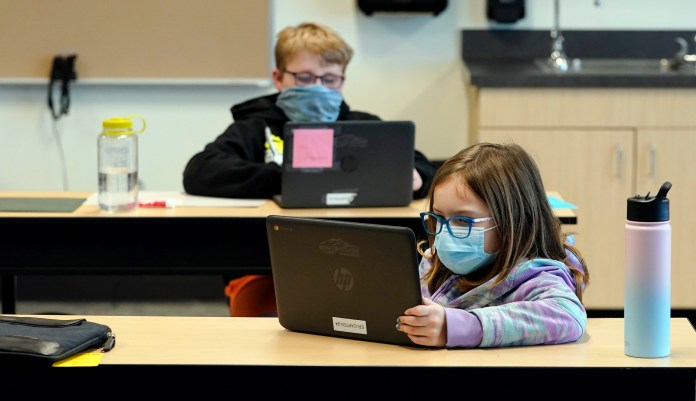 In this Feb. 2, 2021 file photo, students wear masks as they work in a fourth-grade classroom, at Elk Ridge Elementary School in Buckley, Wash. After seeing two academic years thrown off course by the pandemic, school leaders around the country are planning for the possibility of more distance learning next fall at the start of yet another school year.