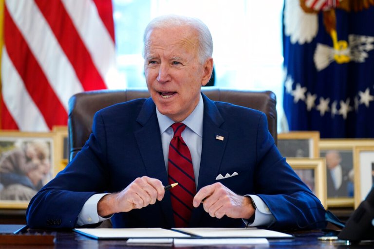 In this Jan. 28, 2021 file photo, President Joe Biden signs a series of executive orders in the Oval Office of the White House in Washington.