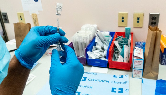 In this Feb. 18, 2021, file photo, a pharmacist prepares a syringe with the Pfizer-BioNTech COVID-19 vaccine at a COVID-19 vaccination site at NYC Health + Hospitals Metropolitan in New York. 