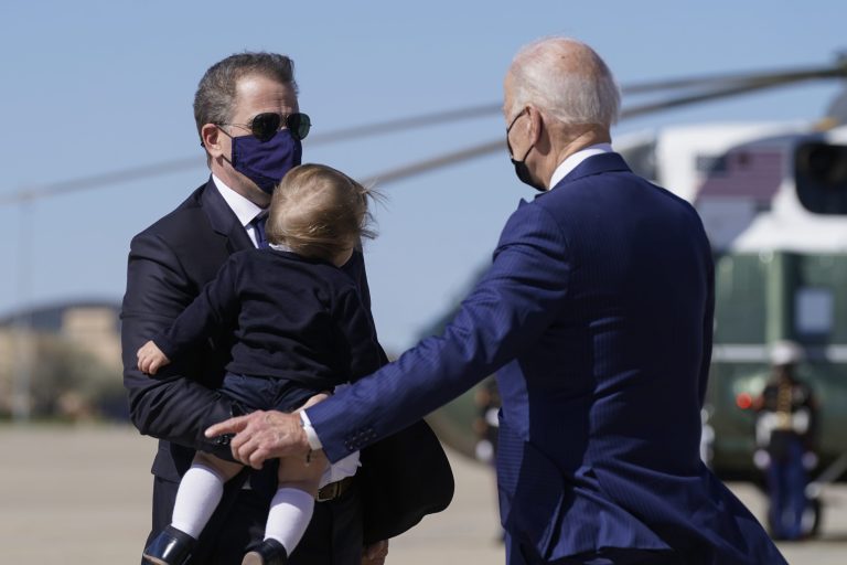 Hunter Biden, the son of President Joe Biden, left, carries his son as he speaks his father.