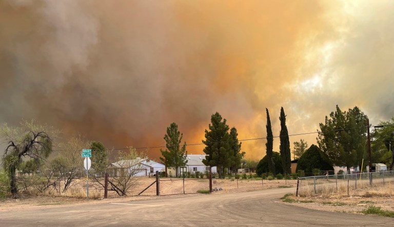 In this Thursday, April 8, 2021, photo provided by Arizona Department of Forestry & Fire Management shows, homes near the intersection of Church Rd and N Dudleyville Rd as the Pinal County Wildfire burns near Dudleyville, Ariz. A small community in south-central Arizona remained under an evacuation notice Friday after crews and air tankers stopped the growth of a wildfire that burned at least 12 homes, officials said.