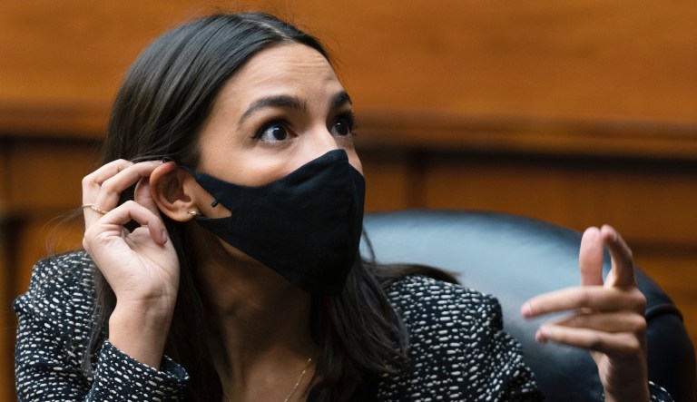 Rep. Alexandria Ocasio-Cortez, D-N.Y. talks to an aide during a House Committee on Oversight and Reform hearing on the Capitol breach on Capitol Hill, Wednesday, May 12, 2021, Washington.