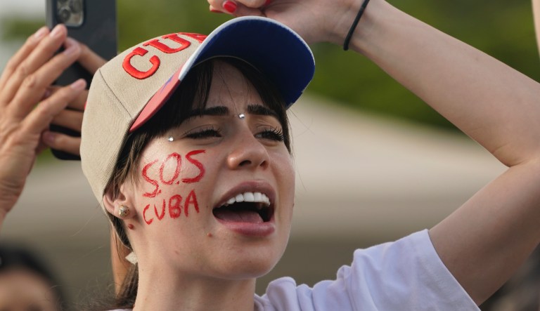 A demonstrator chants as she wears face painted with âSOS Cuba,â Wednesday, July 14, 2021, in Miami's Little Havana neighborhood, as people rallied in support of antigovernment demonstrations in Cuba.