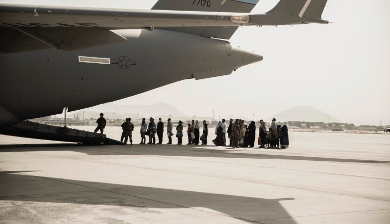 Evacuees wait to board a Boeing C-17 Globemaster III during an evacuation at Hamid Karzai International Airport in Kabul, Afghanistan, Monday, Aug. 30, 2021. 
