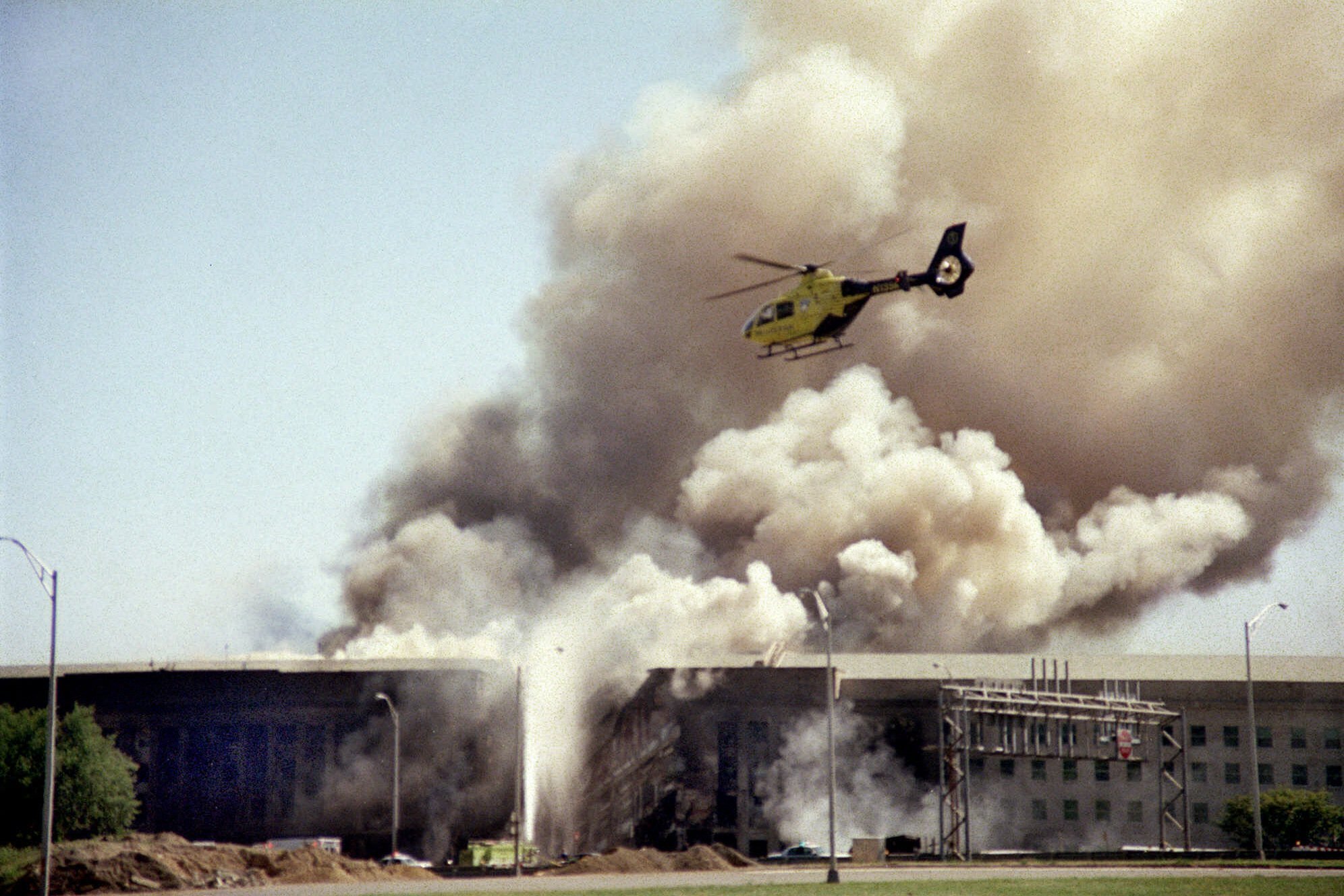 A helicopter flies over the Pentagon in Washington as smoke billows over the building.