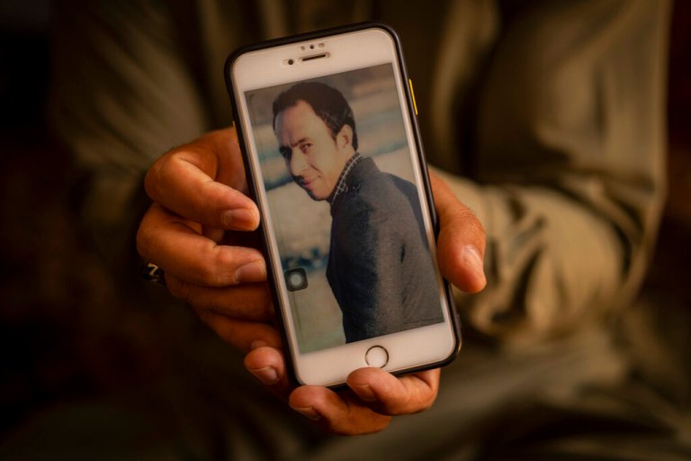 Amal Ahmadi, 32, holds a picture of his slain brother Zemerai Ahmadi at the family house in Kabul, Afghanistan, Monday, Sept. 13, 2021.