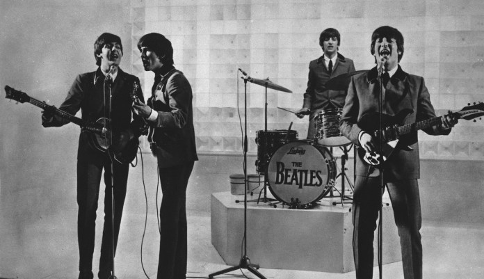 The Beatles are seen performing, date unknown. From left to right: Paul McCartney, George Harrison, Ringo Starr, and John Lennon.