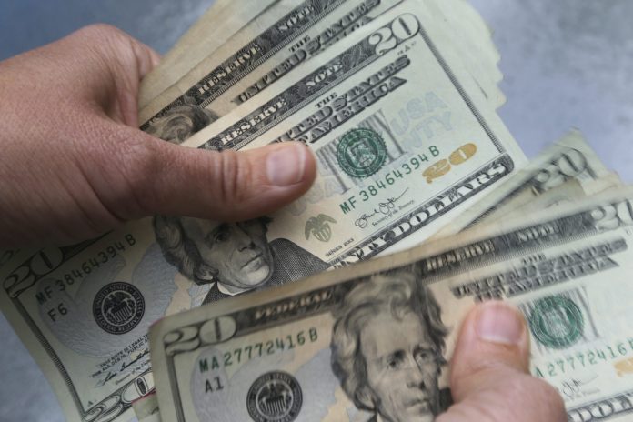 In this June 15, 2018 file photo, $20 bills are counted in North Andover, Massachusetts.