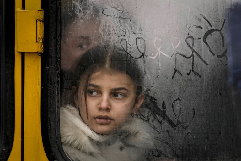 A child looks out a steamy bus window with drawings on it as civilians are evacuated from Irpin, on the outskirts of Kyiv, Ukraine, Wednesday, March 9, 2022. (AP Photo/Vadim Ghirda)
