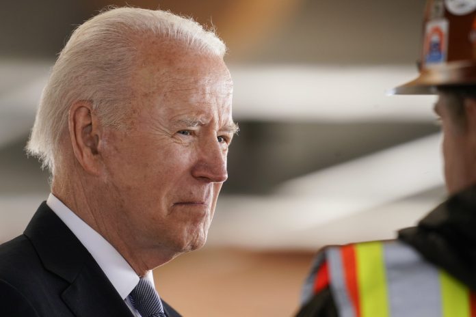 President Joe Biden listens as he tours a construction area at Portland International Airport, Thursday, April 21, 2022, in Portland, Oregon.