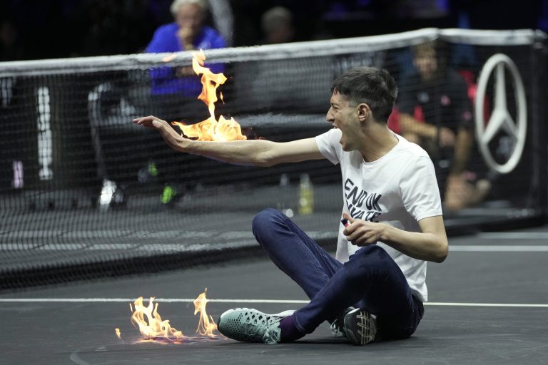 A man sets fire to his arm during a protest at the Laver Cup.