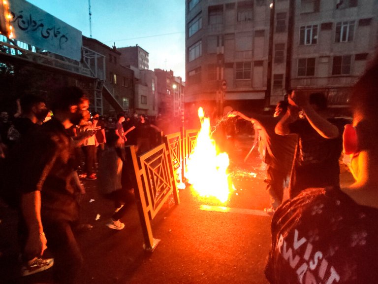 File - In this Wednesday, Sept. 21, 2022, photo taken by an individual not employed by the Associated Press and obtained by the AP outside Iran, protesters make fire and block the street during a protest over the death of a woman who was detained by the morality police, in downtown Tehran, Iran. 