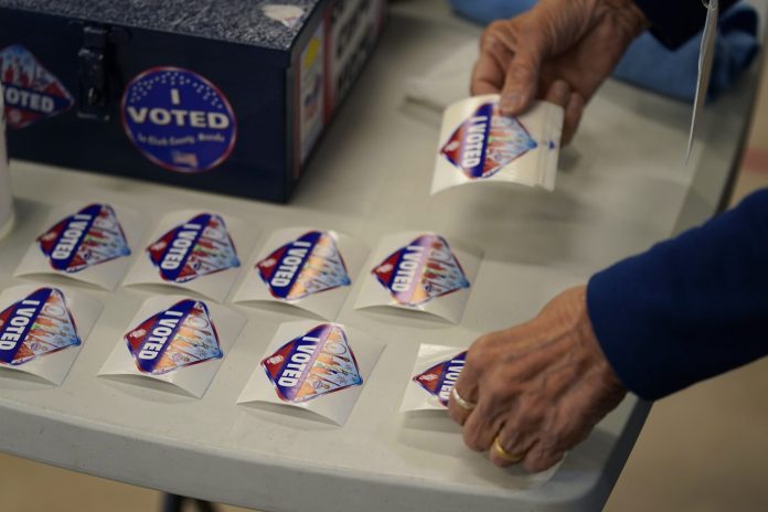 FILE - A pole worker lays out "I Voted" stickers at a polling place June 14, 2022, in Las Vegas. (AP Photo/John Locher, File)